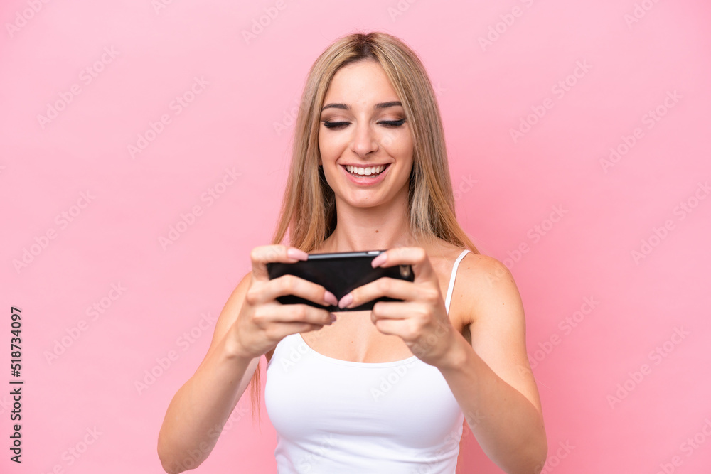 Pretty blonde woman isolated on pink background playing with the mobile phone Pretty blonde woman isolated on pink background playing with the mobile phone