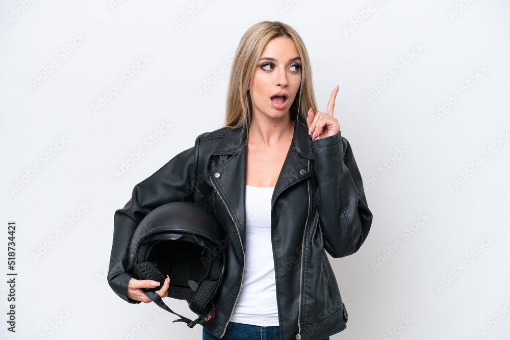 Pretty blonde woman with a motorcycle helmet isolated on white background thinking an idea pointing the finger up Pretty blonde woman with a motorcycle helmet isolated on white background thinking an idea pointing the finger up