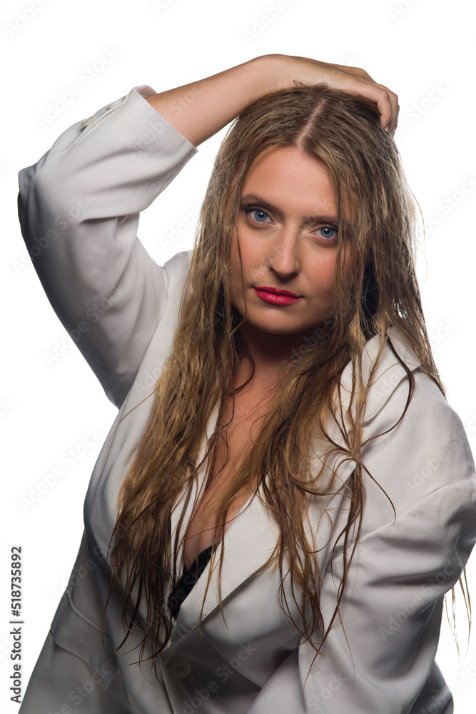 A beautiful blonde with long, wet hair and blue eyes in a white jacket on a white background. Close-up portrait A beautiful blonde with long, wet hair and blue eyes in a white jacket on a white background. Close-up portrait