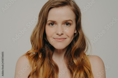 Beauty shot of gorgeous caucasian female with healthy skin isolated on grey background