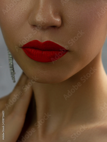 Cosmetics, makeup and trends. Bright lip gloss and lipstick on lips. Closeup of beautiful female mouth with red and pink lip makeup. Beautiful part of female face. Perfect clean skin
