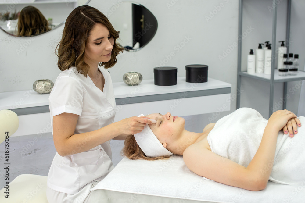 Cosmetologist does a facial massage with a set of gouache Cosmetologist does a facial massage with a set of gouache