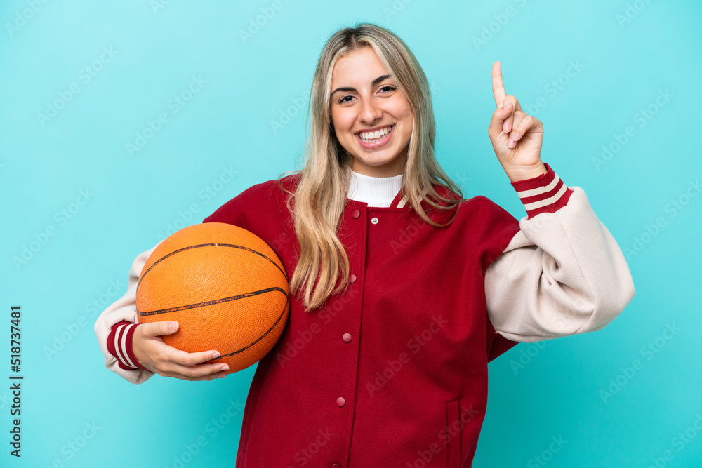 Young caucasian basketball player woman isolated on blue background pointing up a great idea Young caucasian basketball player woman isolated on blue background pointing up a great idea