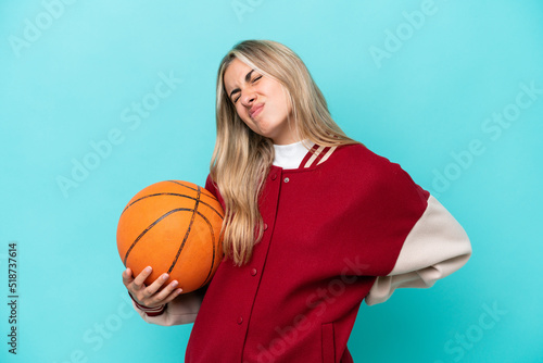 Young caucasian basketball player woman isolated on blue background suffering from backache for having made an effort