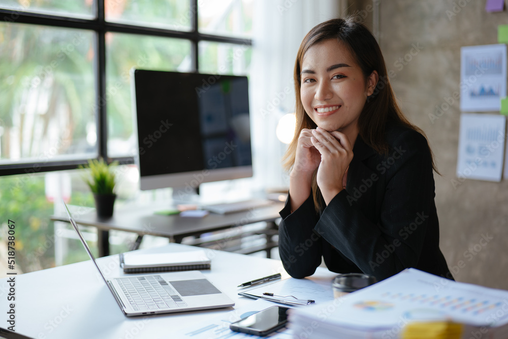 Young beautiful business woman working on chart financial and accounting paperwork and laptop in office space. Young beautiful business woman working on chart financial and accounting paperwork and laptop in office space.