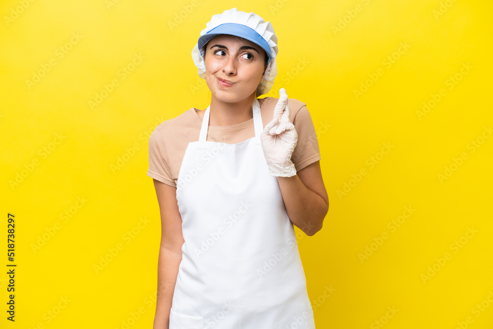 Fishwife woman over isolated background with fingers crossing and wishing the best Fishwife woman over isolated background with fingers crossing and wishing the best