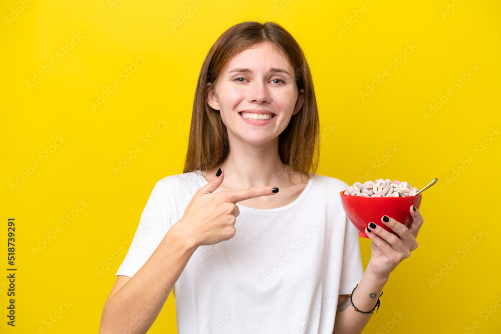 Young English woman holding cup of coffee isolated on yellow background and pointing it Young English woman holding cup of coffee isolated on yellow background and pointing it