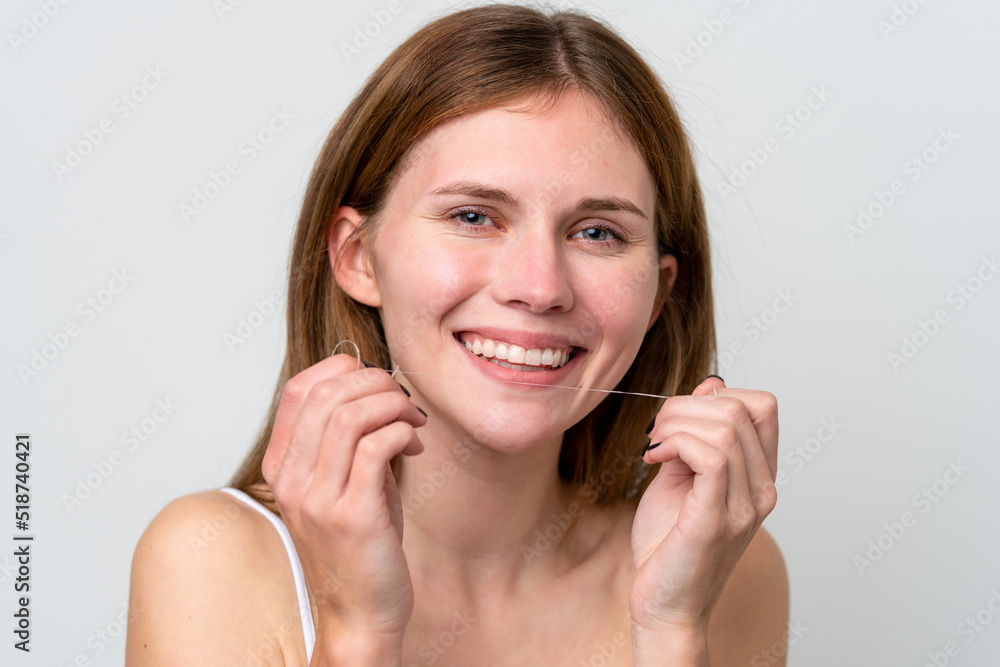Young English woman using dental floss with happy expression. Close up portrait Young English woman using dental floss with happy expression. Close up portrait