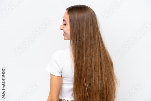 Young caucasian woman isolated on white background in back position and looking side