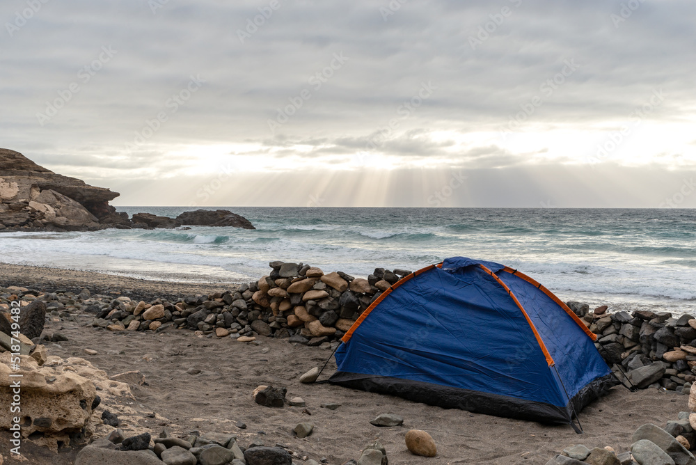 Blue Tent on a Beach Against Ocean and Sunbeam Coming Through Clouds.Fuerteventura,Canary Island