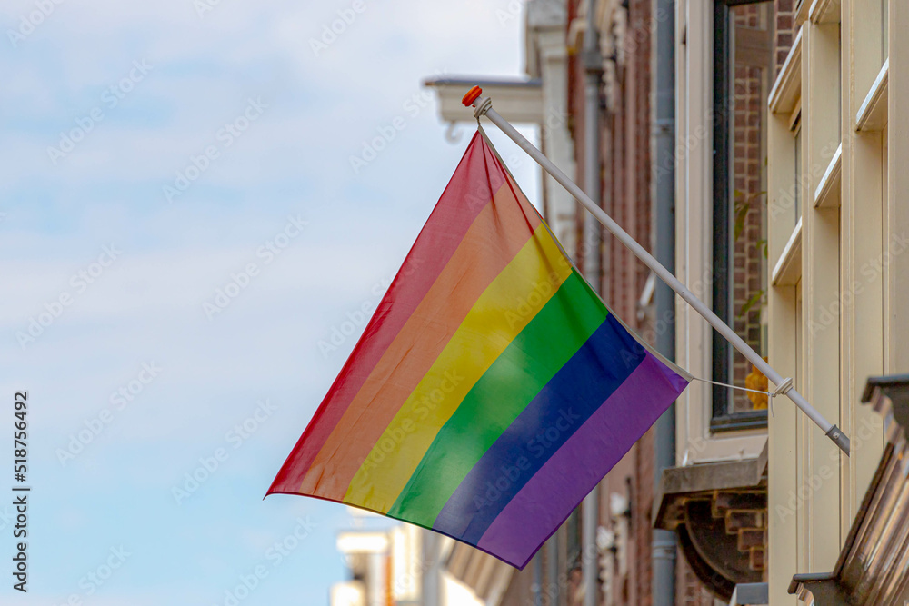 Celebration of pride in Amsterdam with rainbow flags hanging outside building along street, Symbol of Gay, Lesbian, Bisexual and Transgender, LGBT community in Holland, Social movements in Netherlands