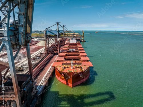 Bulk Carrier Ship Offloading Cargo By Crane for Processing photo
