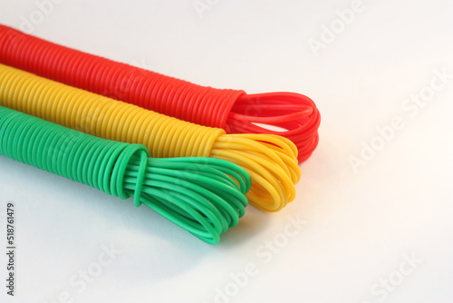 Bright rope for drying clothes on a white background. Products from multi-colored plastic. Free space for text.