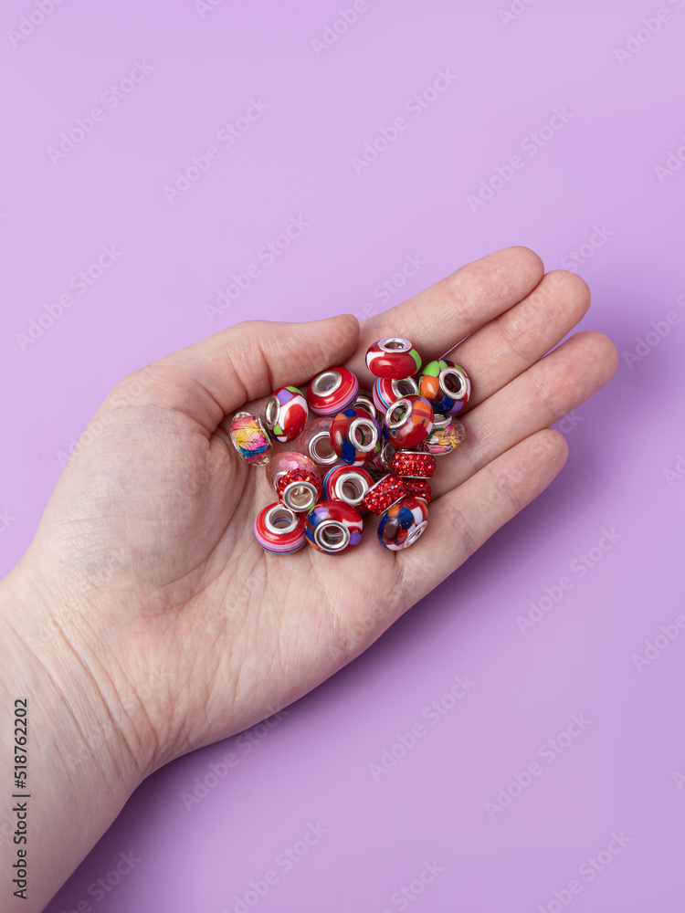 Woman holds beads for creativity on purple background. Creating jewelry Woman holds beads for creativity on purple background. Creating jewelry