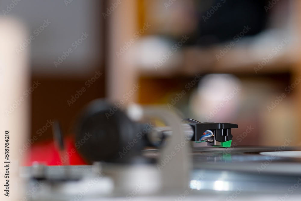 Focus on The Headshell Cartridge and Stylus of Classic Vintage Vinyl Record Player or Turntable Playing on Vinyl Record Music Focus on The Headshell Cartridge and Stylus of Classic Vintage Vinyl Record Player or Turntable Playing on Vinyl Record Music