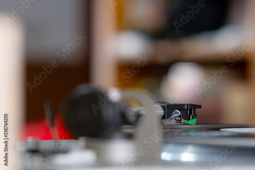 Focus on The Headshell Cartridge and Stylus of Classic Vintage Vinyl Record Player or Turntable Playing on Vinyl Record Music