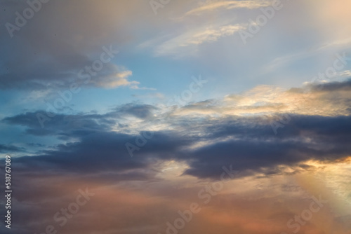 Summer evening sky in the picturesque clouds, lit by the rays of the setting sun. © Anatoliy