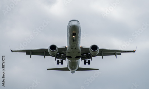 Passenger plane comes in for landing in cloudy weather.