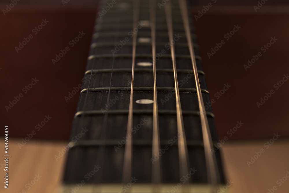 The neck of an acoustic six-string guitar. Close up. The neck of an acoustic six-string guitar. Close up.