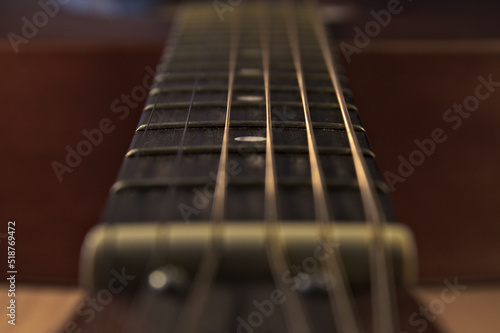 The neck of an acoustic six-string guitar. Macro.