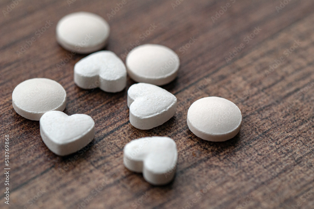 White pills in the shape of a heart White pills in the shape of a heart