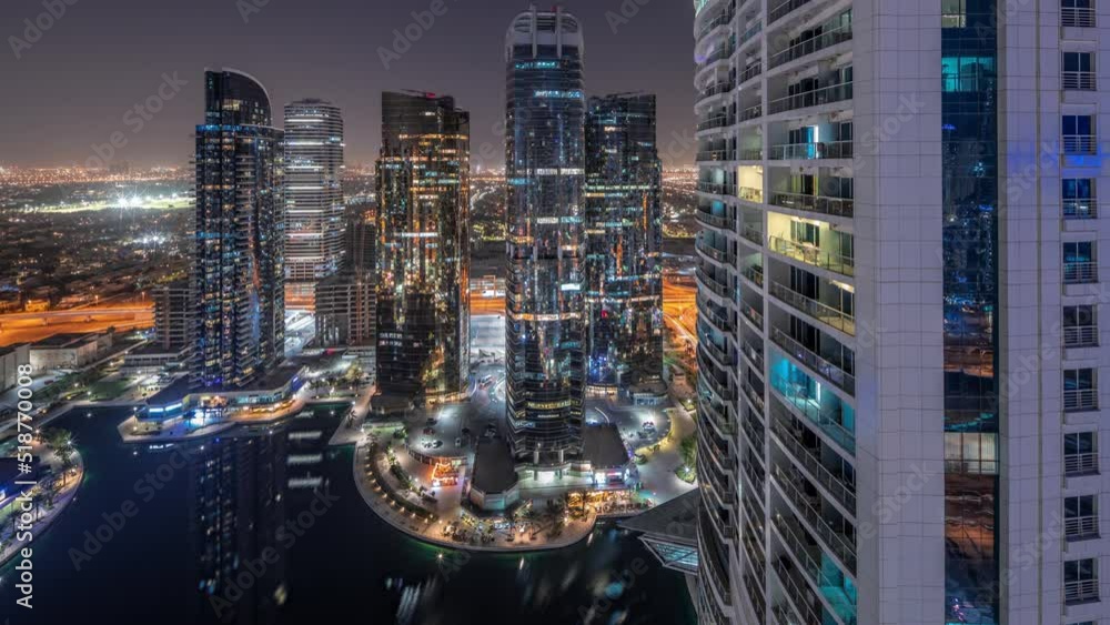 Tall residential buildings at JLT district aerial day to night transition timelapse, part of the Dubai multi commodities centre mixed-use district. Many balconies on towers Tall residential buildings at JLT district aerial day to night transition timelapse, part of the Dubai multi commodities centre mixed-use district. Many balconies on towers