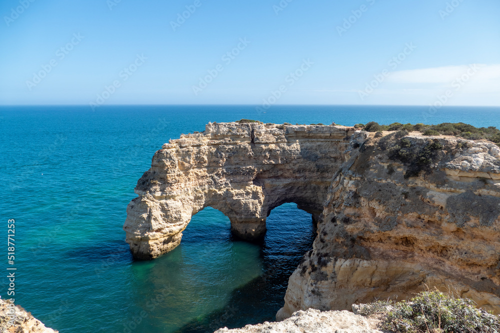 Natural Arch of Marinha Beach during low tide. Landmark in Lagoa, Algarve. Portugal.