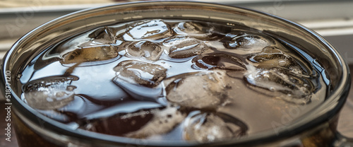 pieces of ice on the surface of the water in a mug close-up