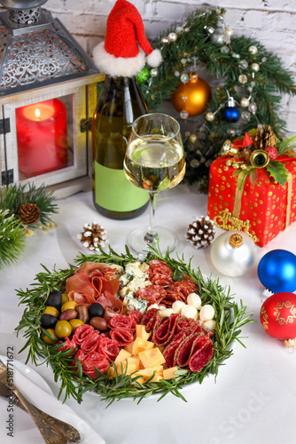 Delicacy assorted appetizer platter of salami and cheese, Parma ham, olives. An original antipasto serving for a Christmas party.