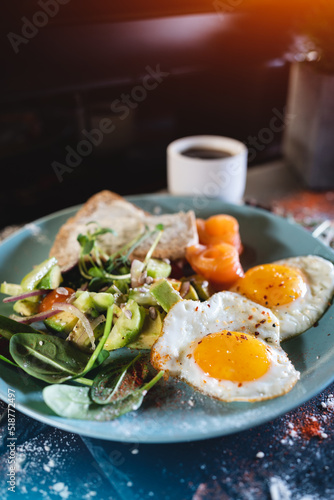fresh breakfast with fried eggs, bread, avocado, red fish salmon and coffee