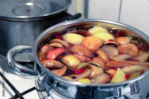 Preparation of a healthy fruit compote in a chrome pan. Fruit compote in a bowl. Fresh and tasty compote