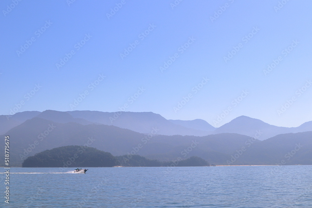 Itagua bay, in Ubatuba, seen from Portinho, with Serra do Mar in the background, on a sunny day in August 2022