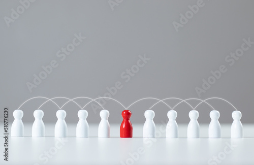 The red wooden puppet stood out from the crowd. social media network A network that connects members. Communication, teamwork, community, society. Abstract concept with pieces of wood.