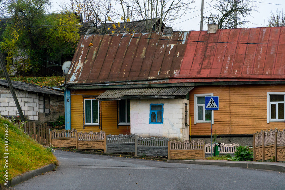 Low small wooden houses along a narrow cozy street. The historical center of a small Belarusian town.