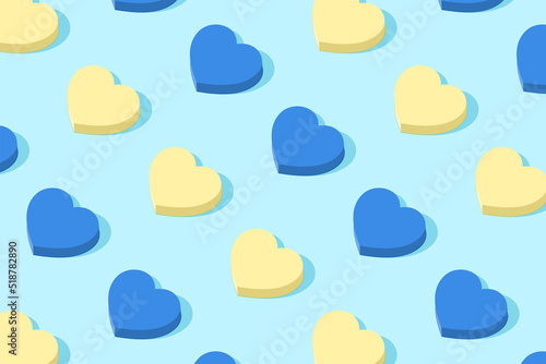 Fashionable pattern in alternation of blue and yellow. Geometric hearts in the pastel colors of the Ukrainian flag. Minimal holiday concept. Solar shadow.