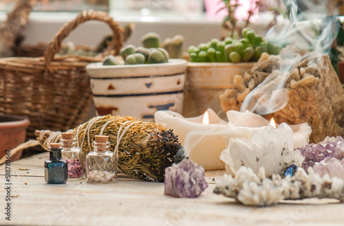 Cozy space with candles, crystals, herbs, and plants. Alternative medicine, herbal medicine, aromatherapy or esoteric background with incense smoke. photo