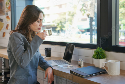 young confidence businesswoman having hot tea while casual working in coffee shop