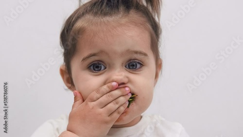 Close-up of the face of a child eating strawberries. High quality. Cute little girl.
