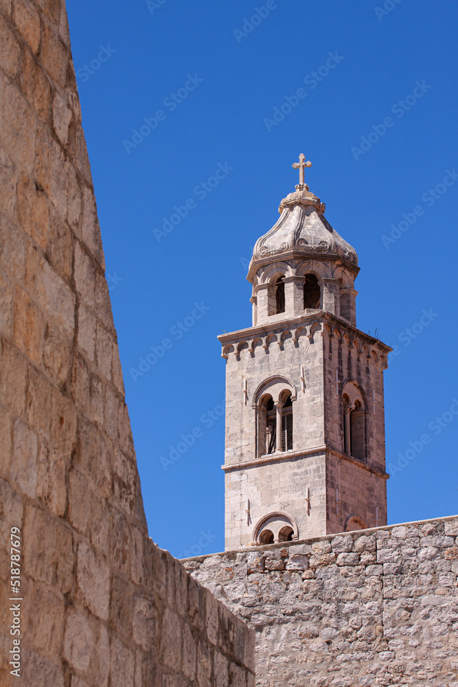 Dominican church tower in Dubrovnik Old Town, Croatia, with city walls in forground.