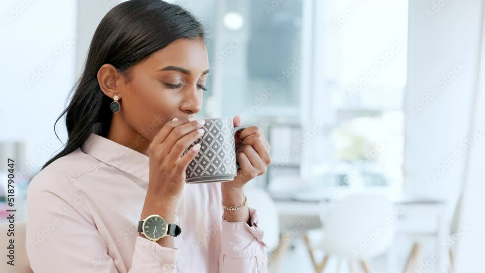 Young business woman drinking a calming, relaxing cup of tea, enjoying the aroma. Happy corporate professional taking a deep breath to enjoy the scent of her drink while resting at work