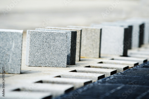 Fototapeta Naklejka Na Ścianę i Meble -  Marble square paving stones are ready for installation. Paving of footpaths and construction of a drainage system. selective focus