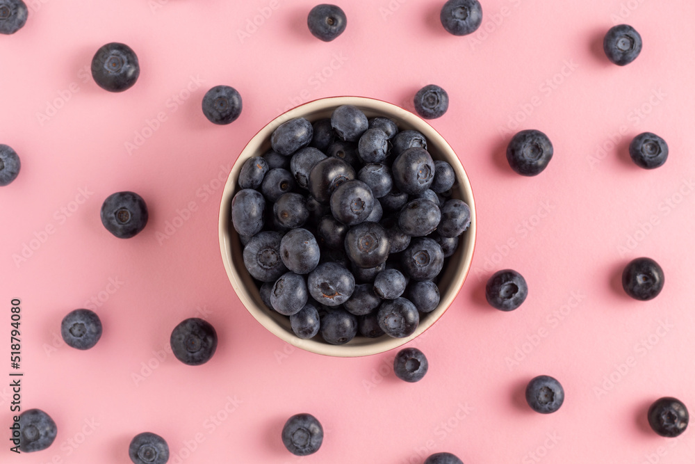 Ripe sweet blueberries on a pink background.
