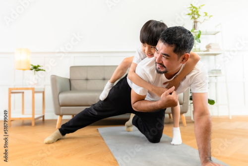 Young asian parents with child meditating at home isolated in room. Family, sport, yoga concept.