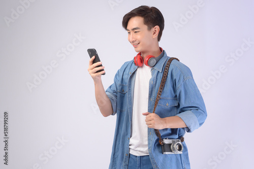 Young happy asian tourist man over white background studio, travel and holidays concept. © tonefotografia