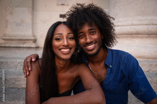 Portrait of an east african couple, smiling lovers cuddle each other.