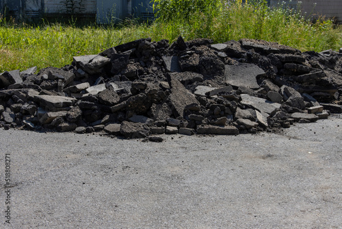 Pieces of dismantled asphalt piled up at the edge of the road