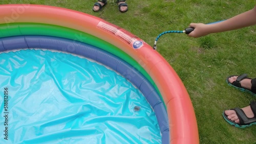 Children inflate a small pool with a pump. The idea of recreation in the yard, in nature. High quality 4k footage