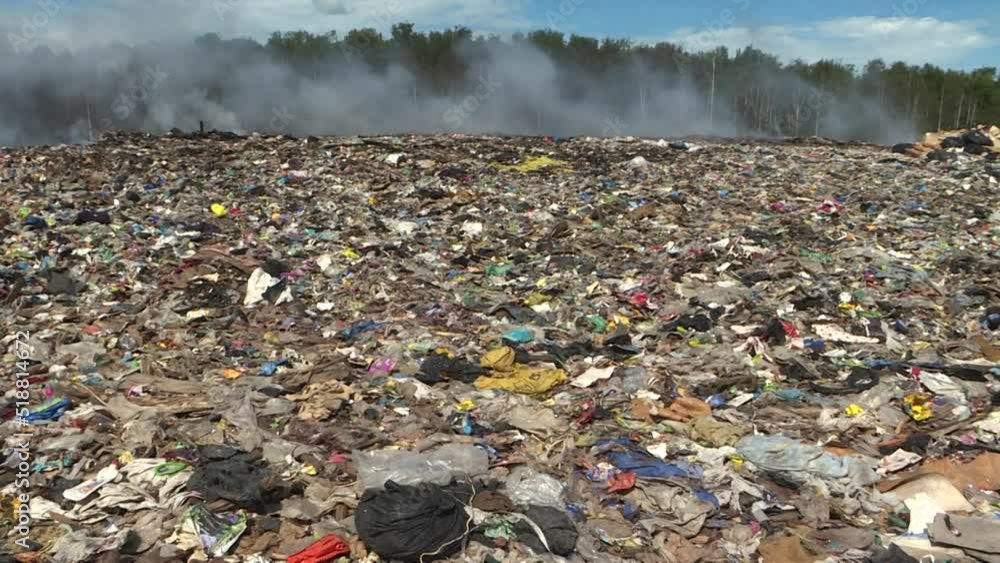 Burning garbage dump, toxic smoke rises into the air, polluting the environment. City dump. Burning garbage dump, toxic smoke rises into the air, polluting the environment. City dump.