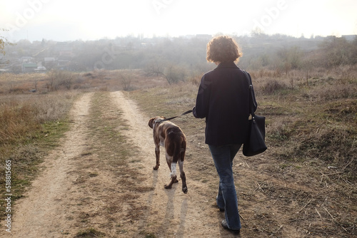 curly young girl walks and plays with a big dog © Игорь Юркивский