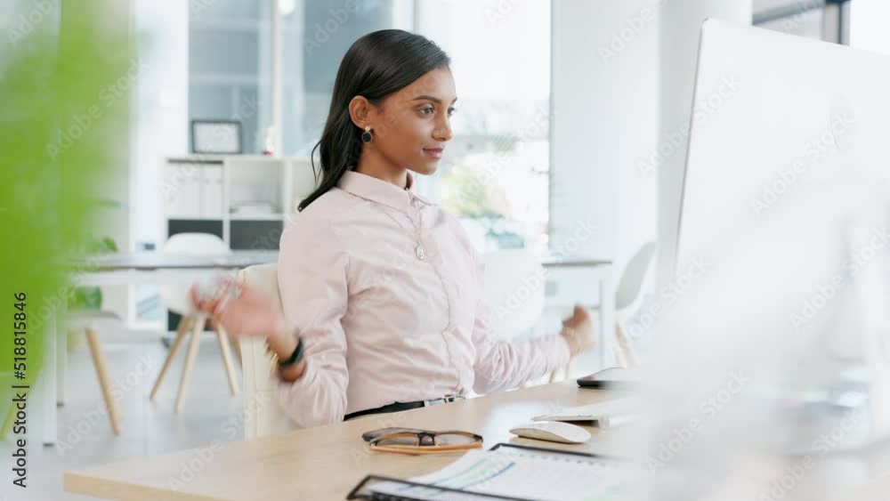 Young business woman stretching before typing an email on a desktop computer alone in an office at work. One Indian female corporate worker taking a break before finishing a deadline on a pc Young business woman stretching before typing an email on a desktop computer alone in an office at work. One Indian female corporate worker taking a break before finishing a deadline on a pc